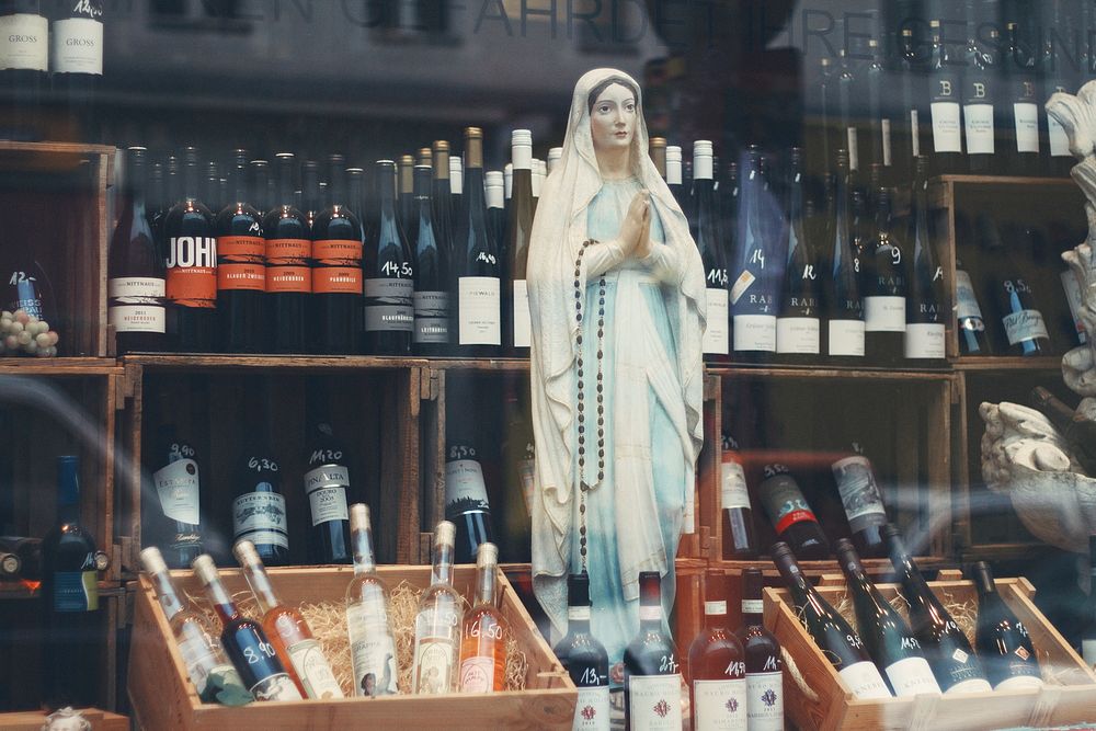 A statue of Virgin Mary with a rosary in a wine store. Original public domain image from Wikimedia Commons