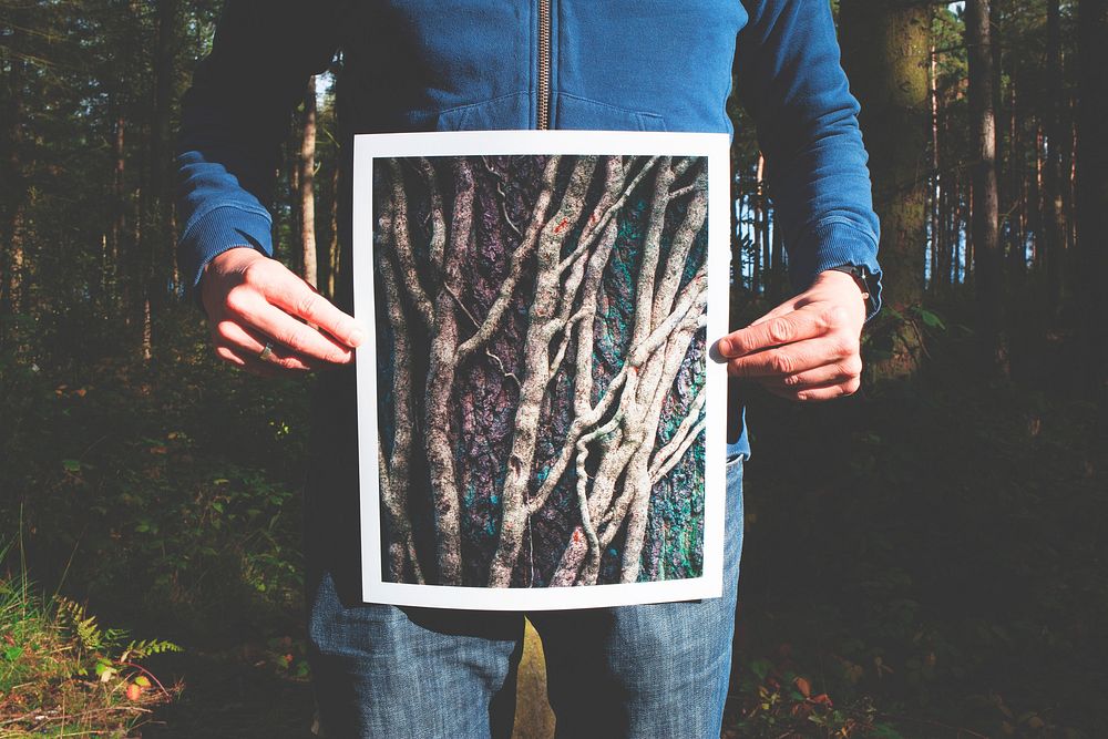 A man holding photo of roots. Original public domain image from Wikimedia Commons