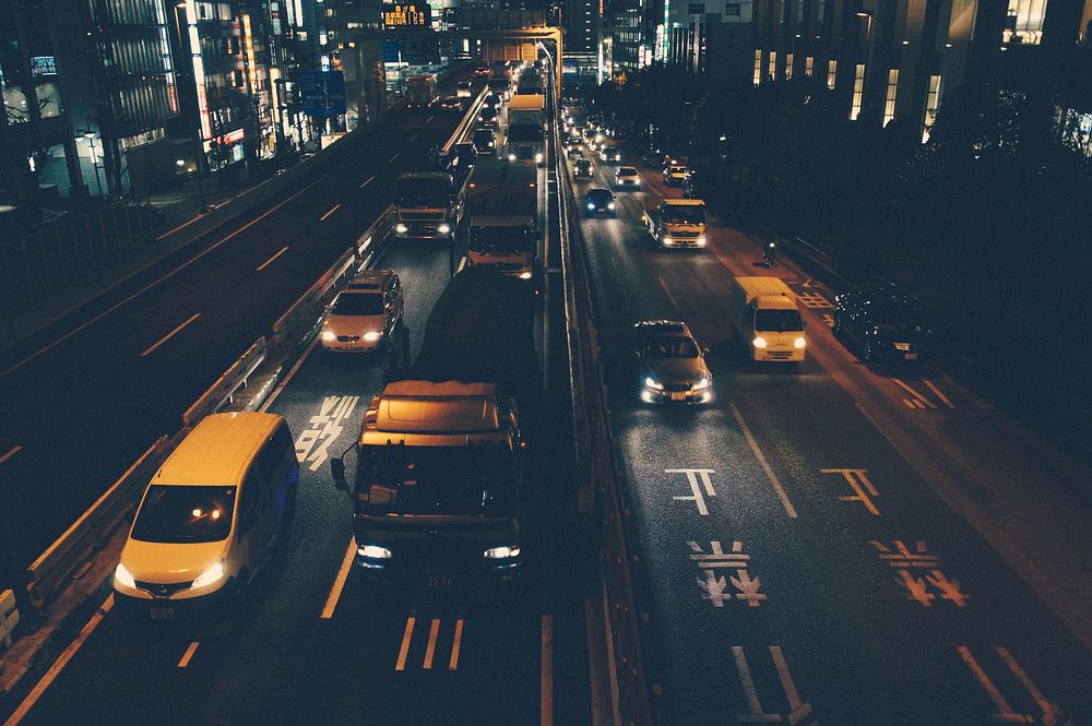 Busy city highway night-time traffic at intersection. Original public domain image from Wikimedia Commons