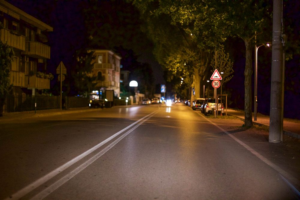Empty city street of Padua glows at night. Original public domain image from Wikimedia Commons