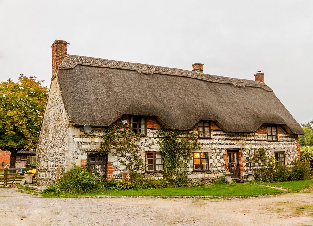 Cozy country cottage with thatched roof in England. Original public domain image from Wikimedia Commons