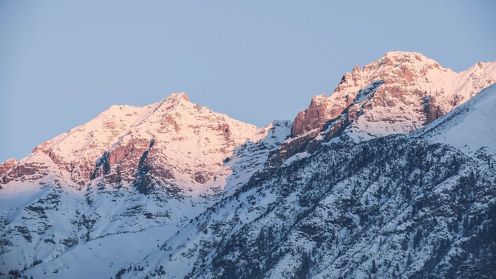 Sunlight falls on the peaks of a snowy mountain range in Innsbruck. Original public domain image from Wikimedia Commons