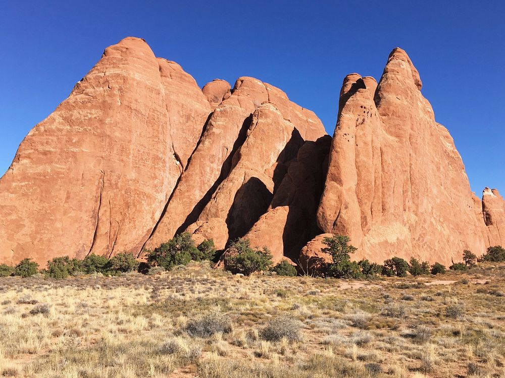 Red rock outcroppings against blue sky. Original public domain image from Wikimedia Commons