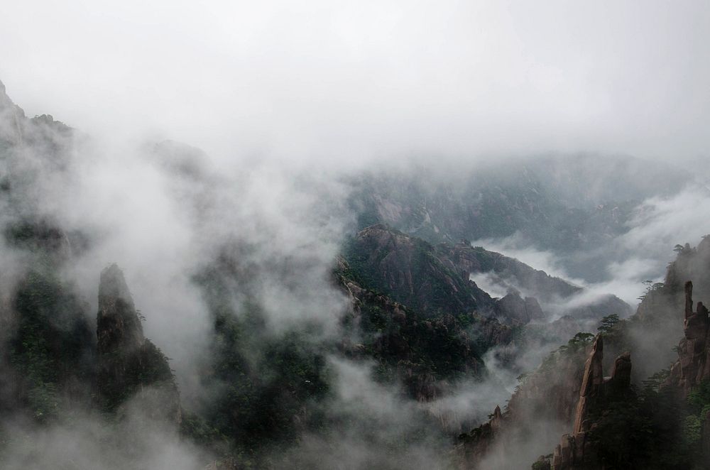 Fog rolling down the rugged mountain ridges of the Huangshan mountain range. Original public domain image from Wikimedia…