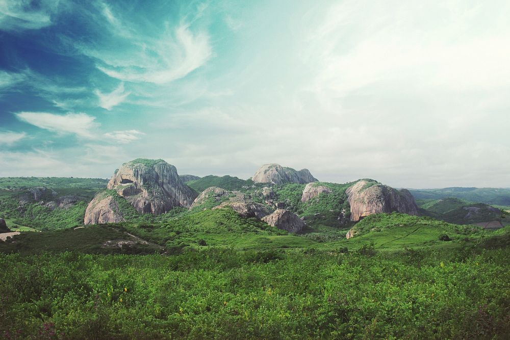 A rock formation with round mossy boulders in a green wilderness. Original public domain image from Wikimedia Commons