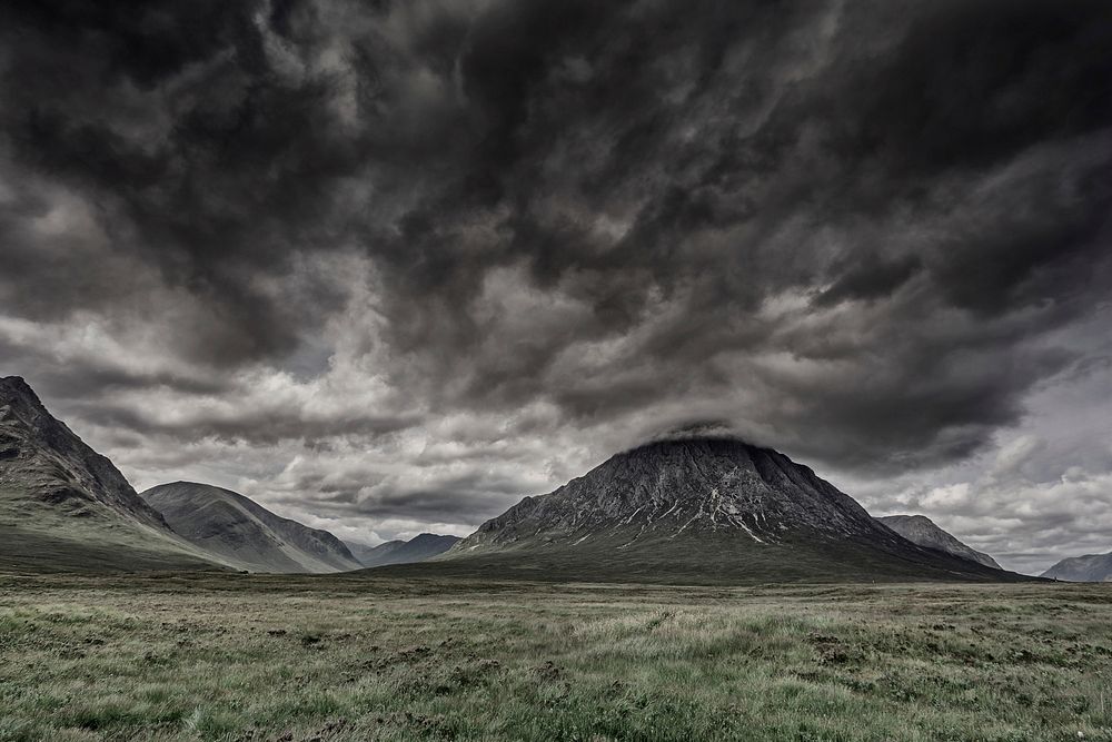 Dark, storm clouds above the valley with small rocky hills at Glencoe. Original public domain image from Wikimedia Commons