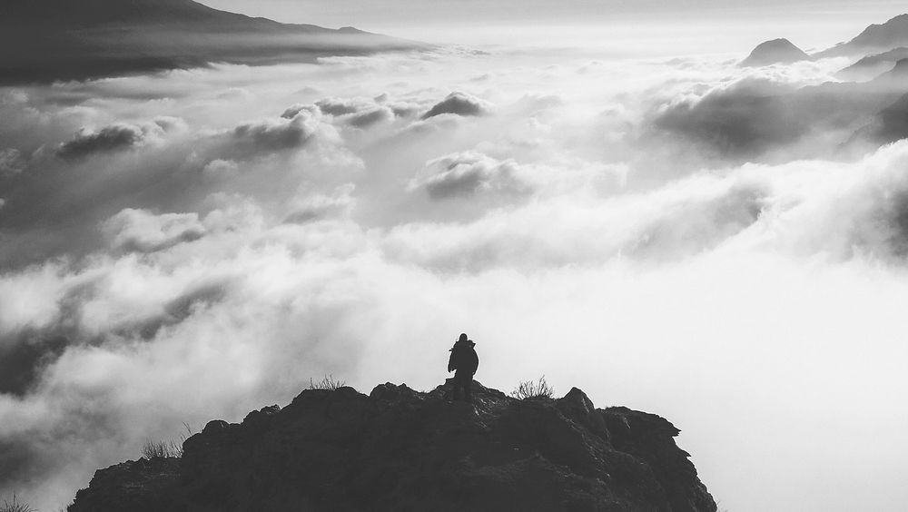 Silhouette of hiker at the summit of a mountain surrounded by fog. Original public domain image from Wikimedia Commons
