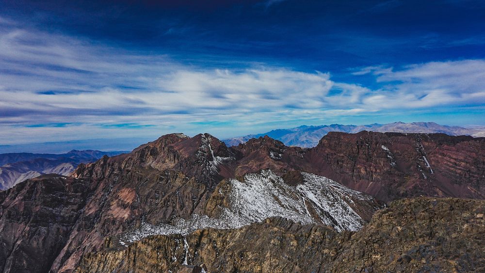 Craggy mountains under a blue sky with fluffy clouds in Toubkal. Original public domain image from Wikimedia Commons