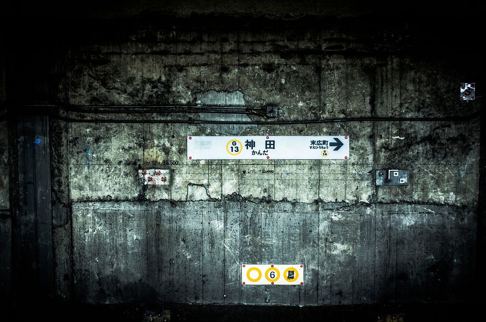White signs showing the direction on a worn-out wall at a railway station. Original public domain image from Wikimedia…