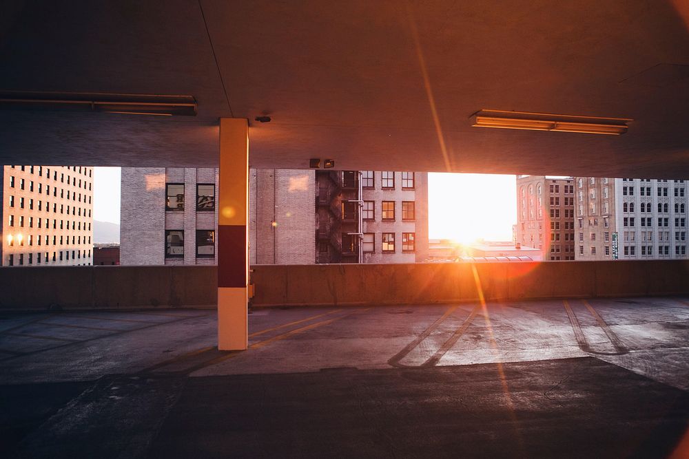 Sun peeking through an empty city car park next to buildings in Salt Lake City. Original public domain image from Wikimedia…