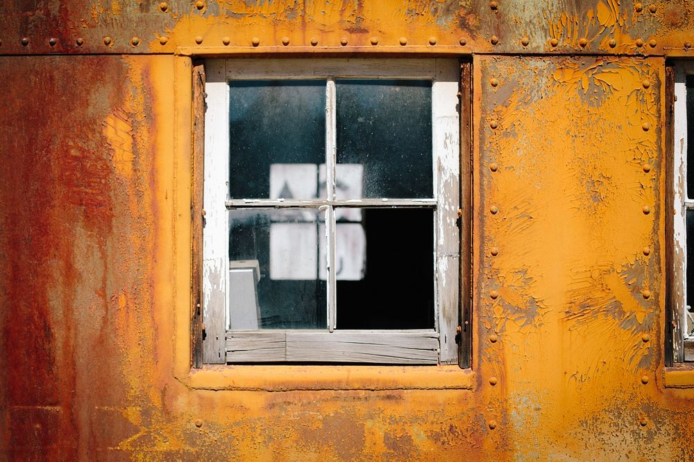 The close-up view of a glass window of a rusty and old metal building in western pacific railroad museum.. Original public…