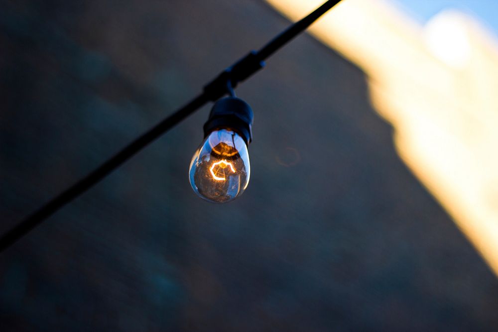 A single light bulb hanging on a black cable in New Orleans. Original public domain image from Wikimedia Commons