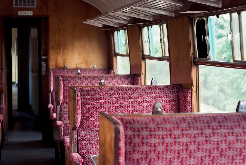 Interior of the old vintage British railway passenger carriage with wooden benches in Ropley. Original public domain image…