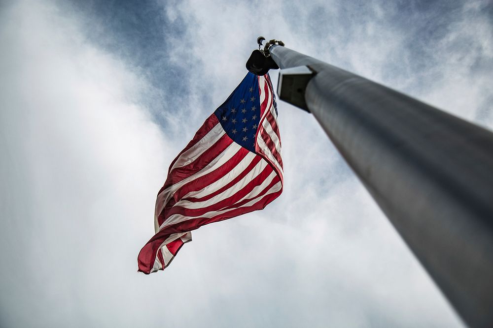 The American flag hanging on a flag pole blowing in the wind in Washington. Original public domain image from Wikimedia…
