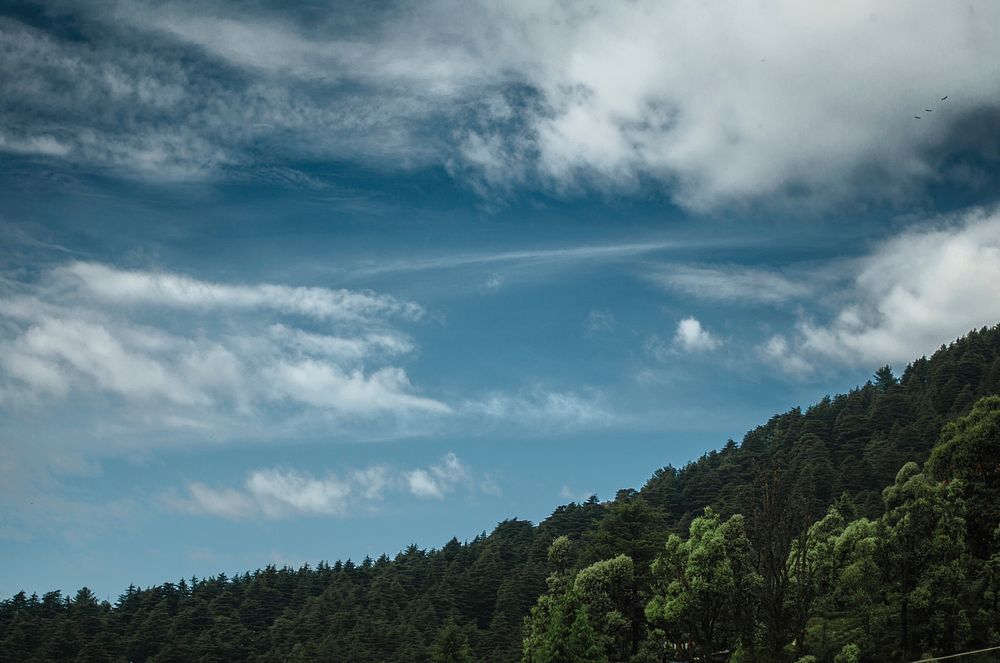 Patchy clouds over a wooded slope in Dharamkot. Original public domain image from Wikimedia Commons