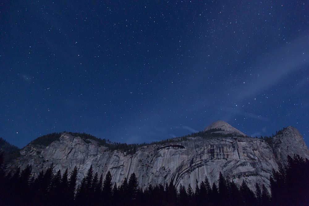 A granite cliff in Yosemite under a starry night sky. Original public domain image from Wikimedia Commons