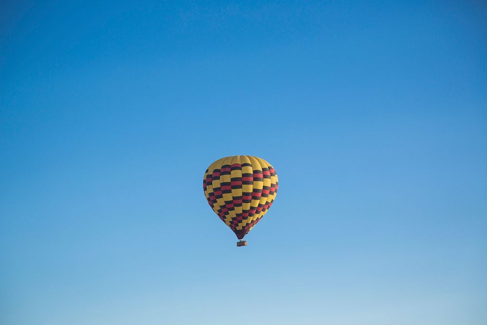A colorful hot air balloon soaring high up in the sky. Original public domain image from Wikimedia Commons