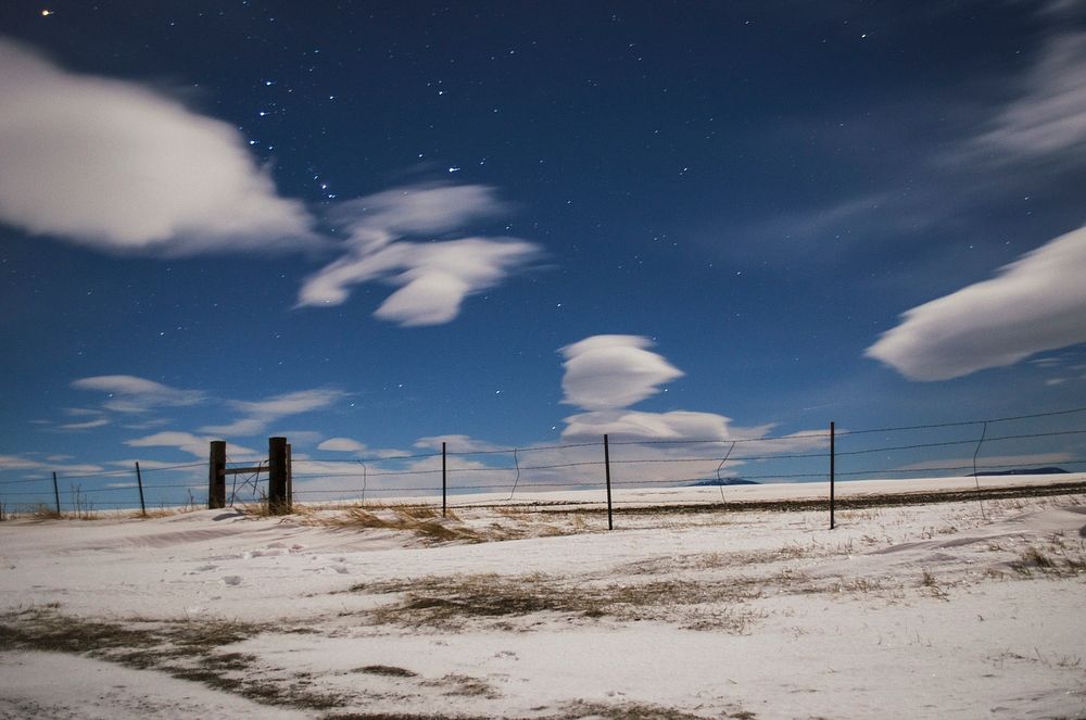 View of the cloudy star speckled sky at a fence near Great Falls. Original public domain image from Wikimedia Commons