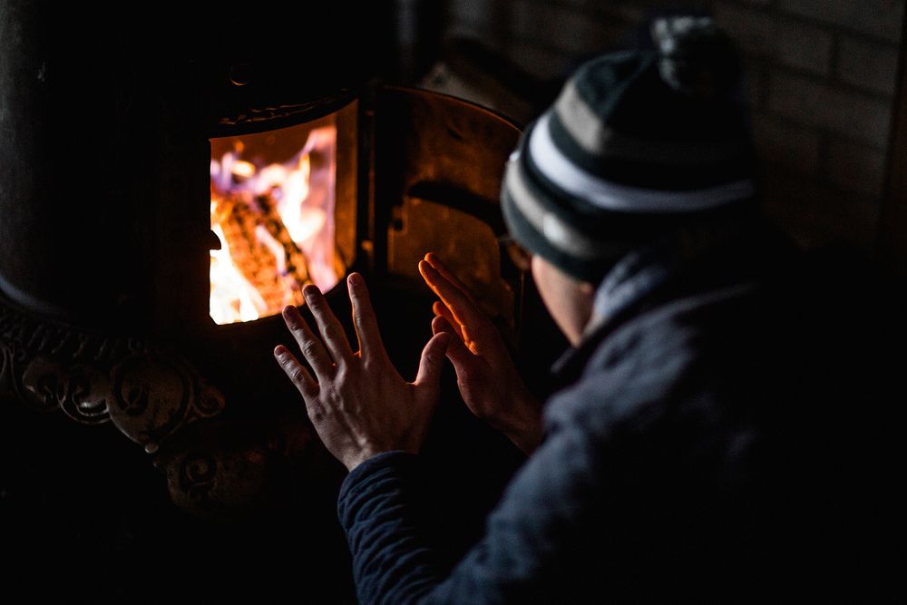 Person warming up by the fire. Original public domain image from Wikimedia Commons