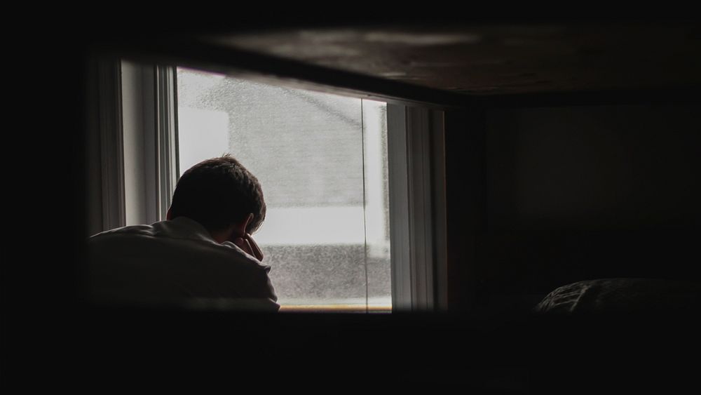 A man longingly looking out of a foggy window. Original public domain image from Wikimedia Commons