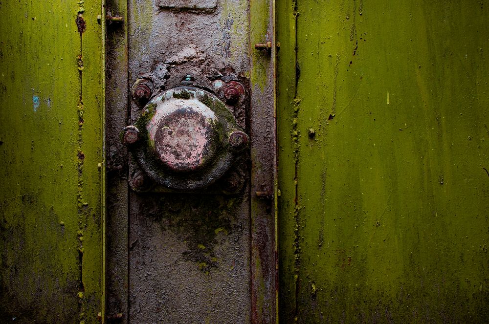 A close-up of a rusty metal knob on a green strongbox. Original public domain image from Wikimedia Commons