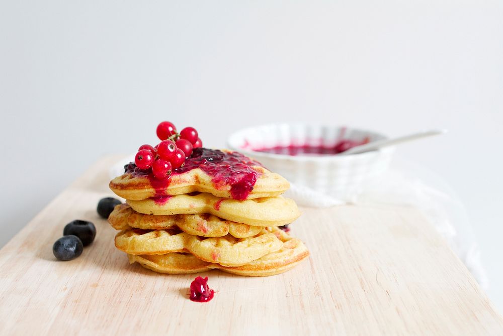 Red currants, blueberries and marmalade on a stack of heart-shaped waffles. Original public domain image from Wikimedia…