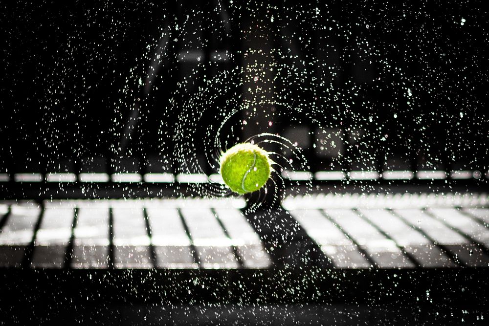 Wet tennis ball spinning with the water spraying off. Original public domain image from Wikimedia Commons
