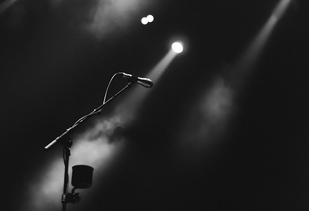 Microphone on stage greyscale. Original public domain image from Wikimedia Commons