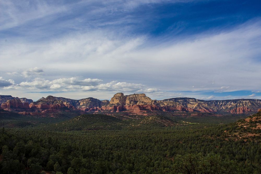 Red rock formations near a green forest in Sedona. Original public domain image from Wikimedia Commons