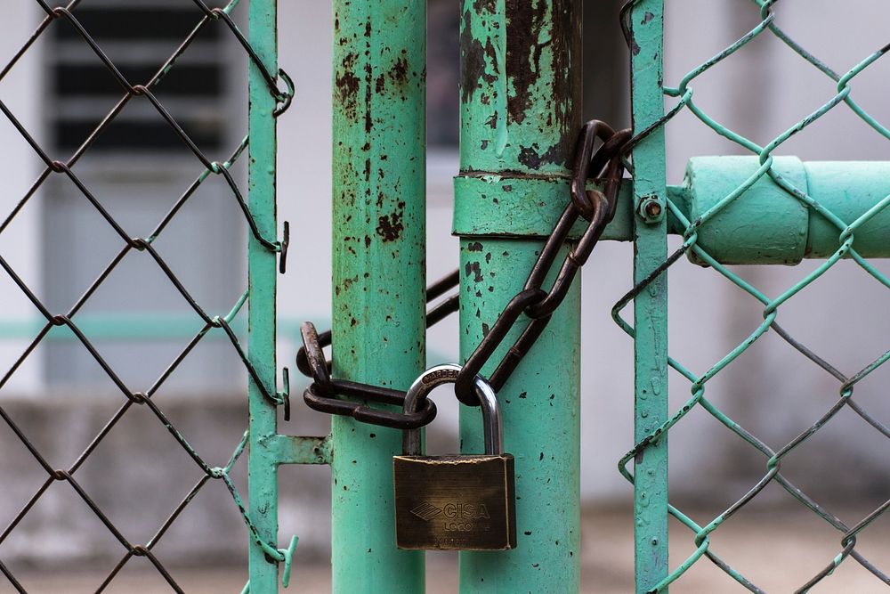 A turquoise chainlink fence with a padlock in Greece. Original public domain image from Wikimedia Commons