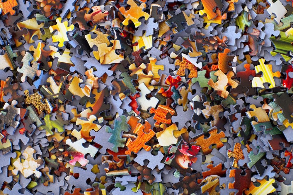 An aerial shot of brightly-colored jigsaw puzzle pieces. Original public domain image from Wikimedia Commons
