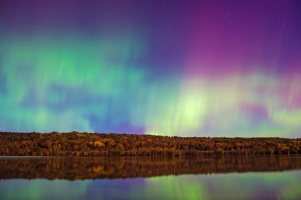 Colorful northern lights in the night sky over a tranquil lake in Houghton. Original public domain image from Wikimedia…
