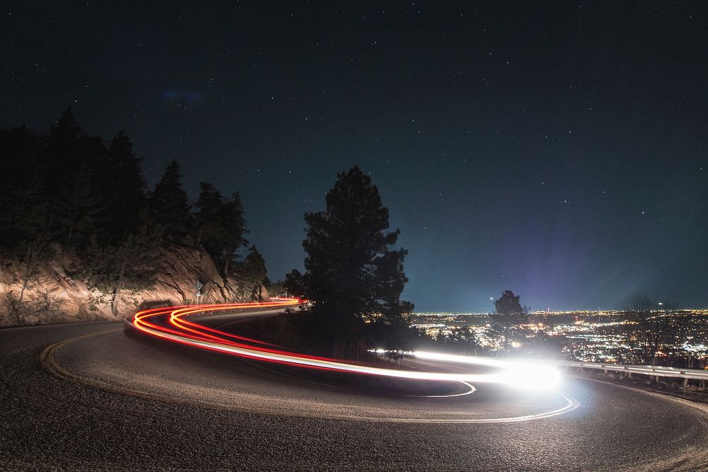 A slow shutter shot of a curved road in Boulder, with fast-driving car light trails. Original public domain image from…