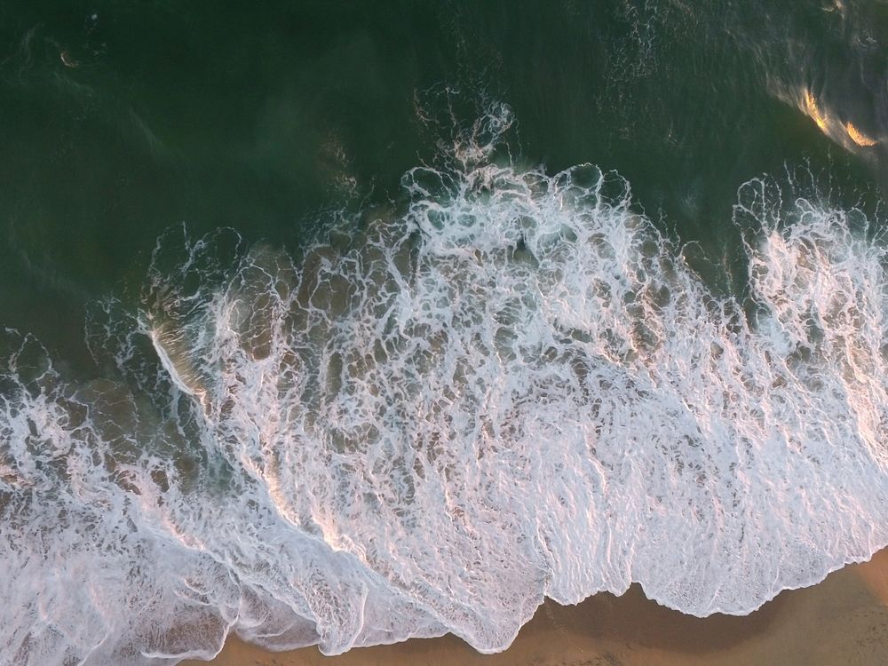Drone aerial view of the ocean foam washing on the Huntington Beach, California, United States. Original public domain image…