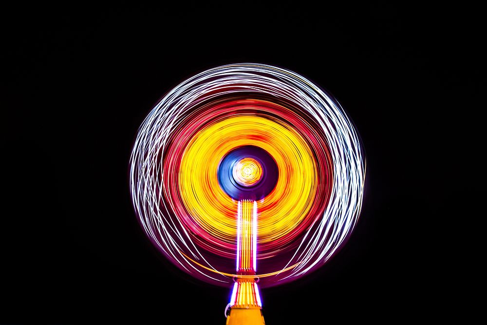 A bright white, yellow and red light painting made by a ride at a fair in Cocoa Beach. Original public domain image from…
