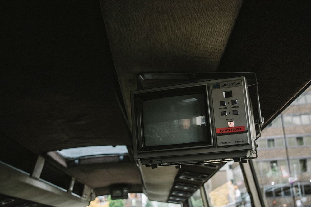An old electronic television attached to the ceiling of a retro looking bus.. Original public domain image from Wikimedia…