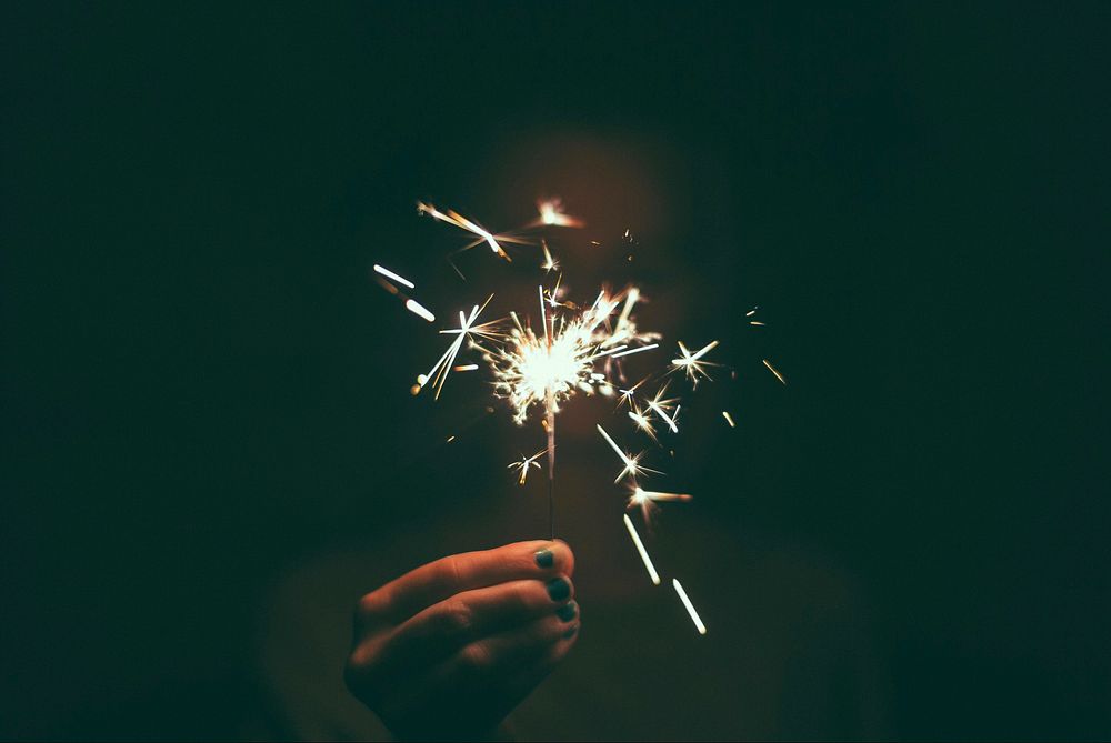 Person holding a lighted sparkler. Original public domain image from Wikimedia Commons