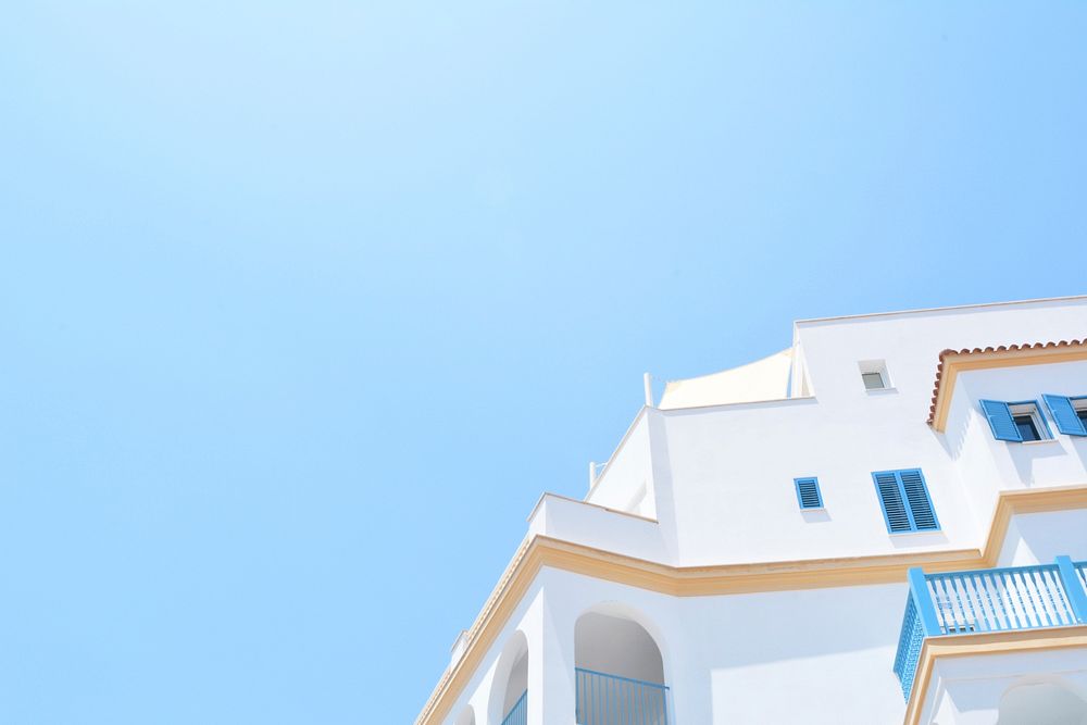 A white Mediterranean-style building under a blue sky. Original public domain image from Wikimedia Commons