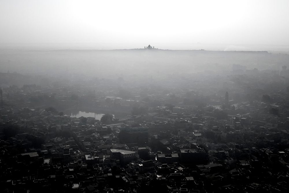 Black and white shot of city with haze and Taj Mahal on the horizon. Original public domain image from Wikimedia Commons
