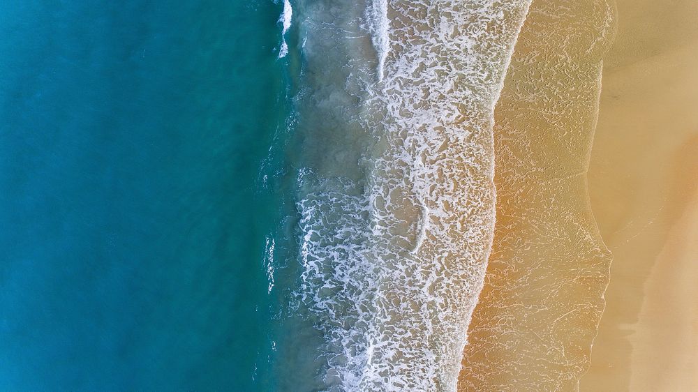 Ocean washing, sandy beach, drone view. Original public domain image from Wikimedia Commons