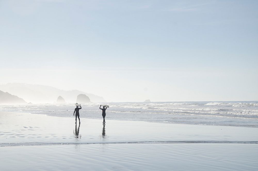 Two surfers carrying surfboards, beach. Original public domain image from Wikimedia Commons