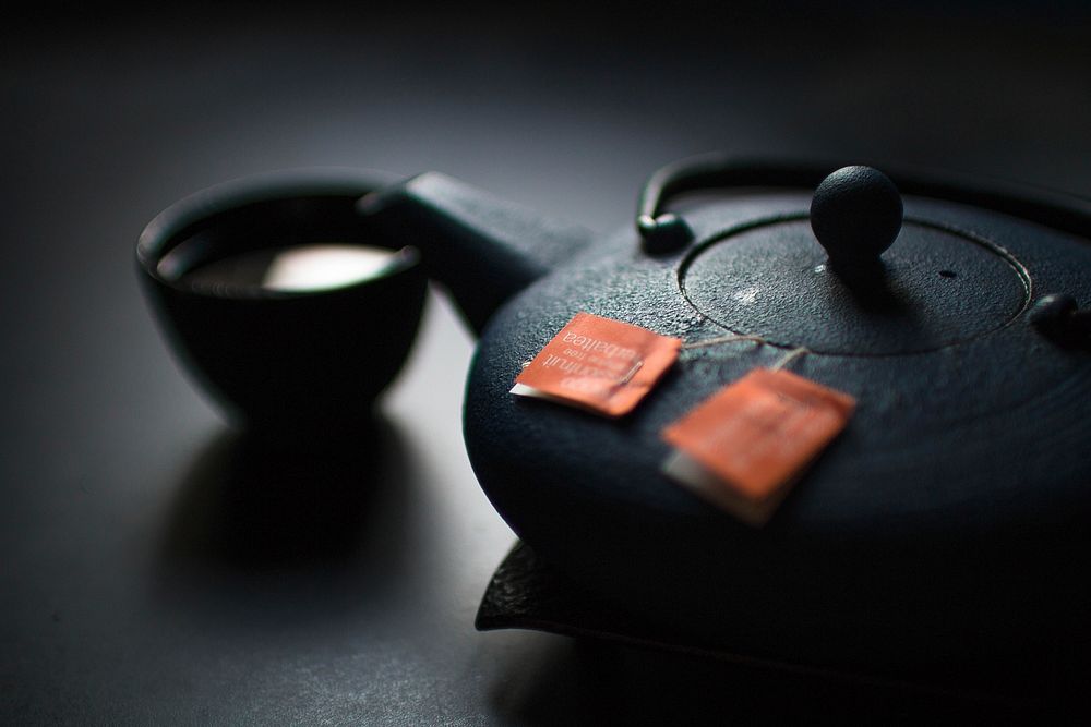 Two tea bags in the black ceramic tea pot with a cup. Original public domain image from Wikimedia Commons