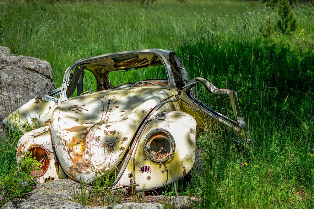 Rusted Volkswagon bug abandoned in the field.. Original public domain image from Wikimedia Commons