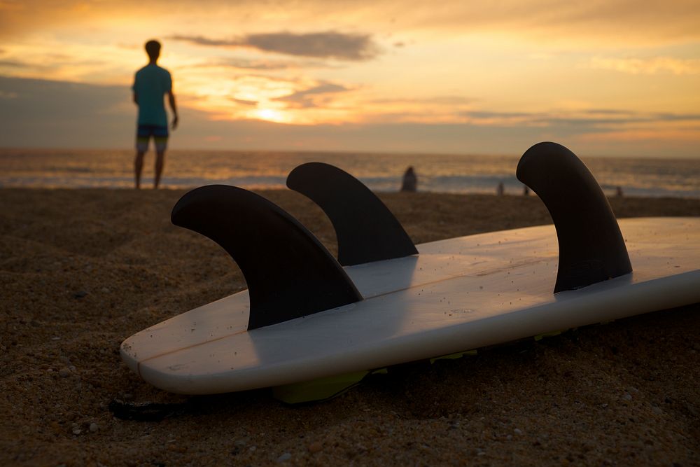 Surfboard fins on the sand beach during sunset. Original public domain image from Wikimedia Commons