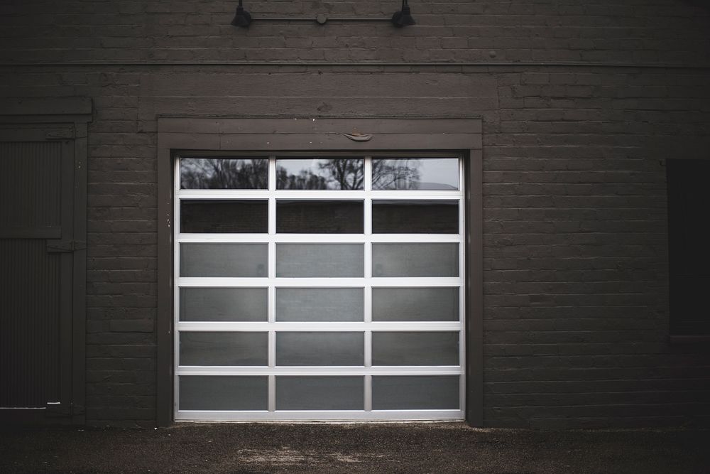 The garage door of a building made from glass with dark brick walls in Grand Rapids.. Original public domain image from…