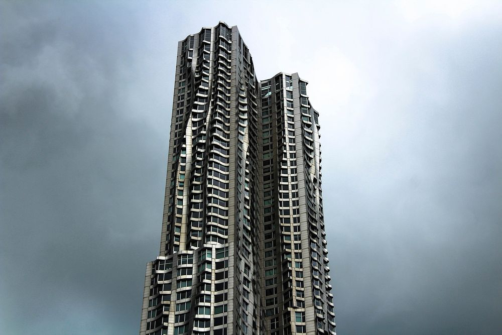 Twin skyscrapers with undulating curved facade rise against the gray sky.. Original public domain image from Wikimedia…