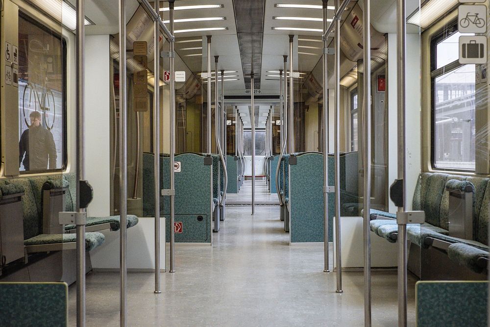 Interior shot of empty subway carriage with man walking outside. Original public domain image from Wikimedia Commons