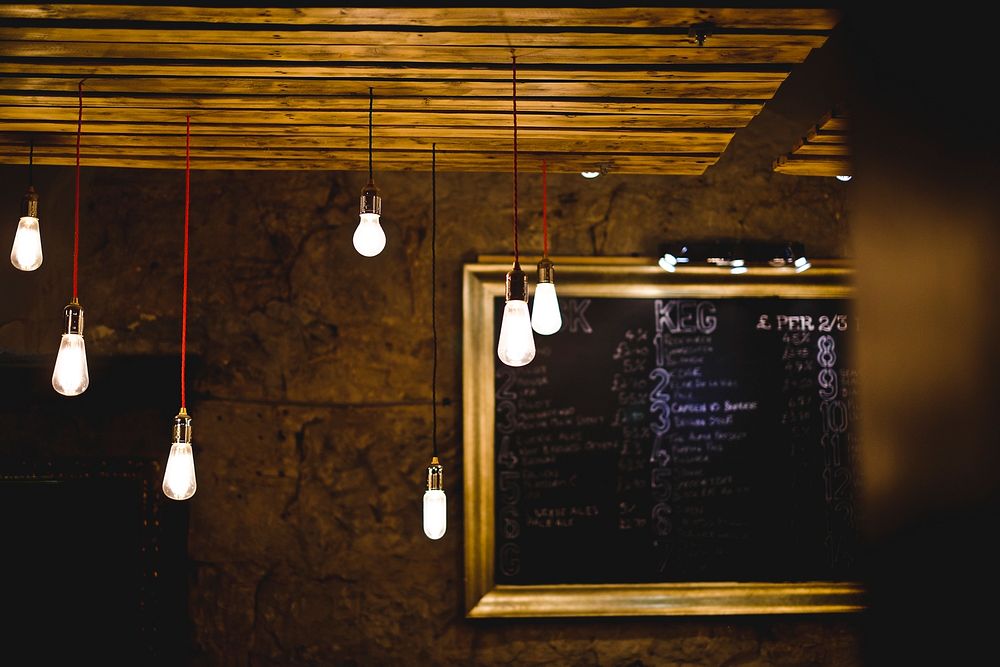 Industrial light bulbs hand from the ceiling in a rustic restaurant. Original public domain image from Wikimedia Commons
