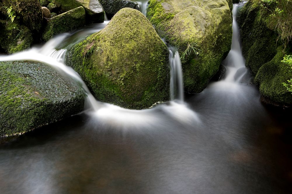 Multiple waterfall streams flowing through mossy boulders. Original public domain image from Wikimedia Commons