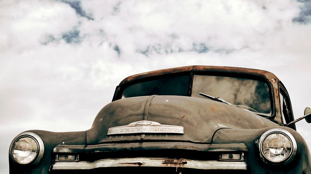 Front view of a rusted vintage car prominently featuring the hood.. Original public domain image from Wikimedia Commons